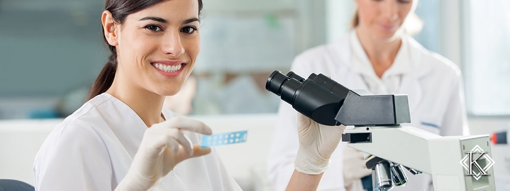 Laboratorista em laboratório em frente a microscópio. Conheça mais sobre a Aposentadoria Especial para Técnico de Laboratório.