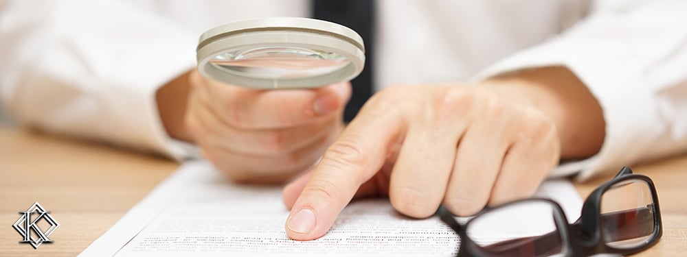 Homem analisando contrato com uma lupa