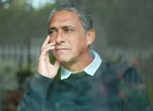 A imagem mostra um homem de meia idade, pensativo, com uma das mãos apoiada no rosto, olhando para o horizonte. Ilustra o texto sobre perícia negada.