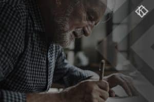 A imagem mostra um homem de barba branca em uma escrivaninha fazendo anotações. Ilustra a publicação 