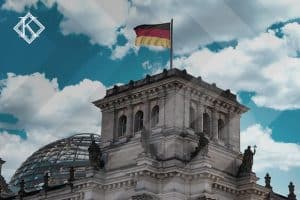 A imagem mostra um prédio histórico com uma bandeira da Alemanha no topo, e ilustra a publicação 