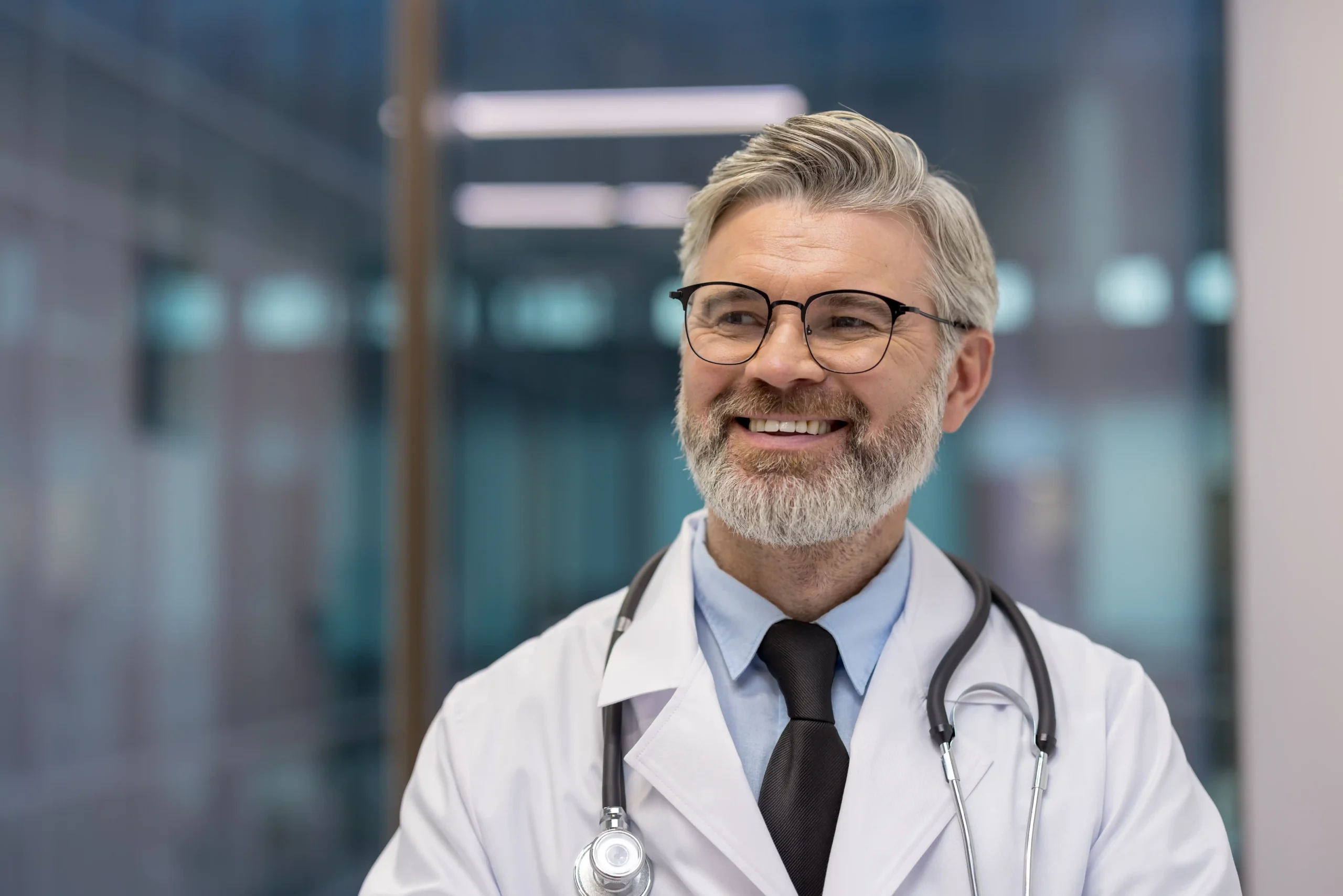 A imagem mostra um médico maduro, usando jaleco, estetoscópio em volta do pescoço, sorrindo. Ilustra o texto sobre grau de insalubridade.