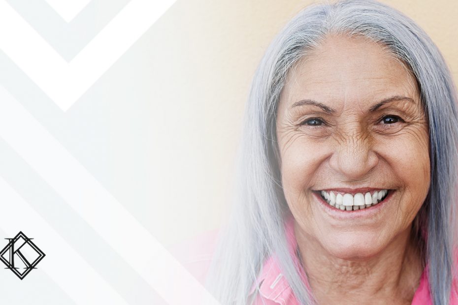 A imagem mostra uma mulher sorrindo, e ilustra a publicação "Aposentadoria por idade em 2022 - saiba se pode se aposentar!", da Koetz Advocacia.