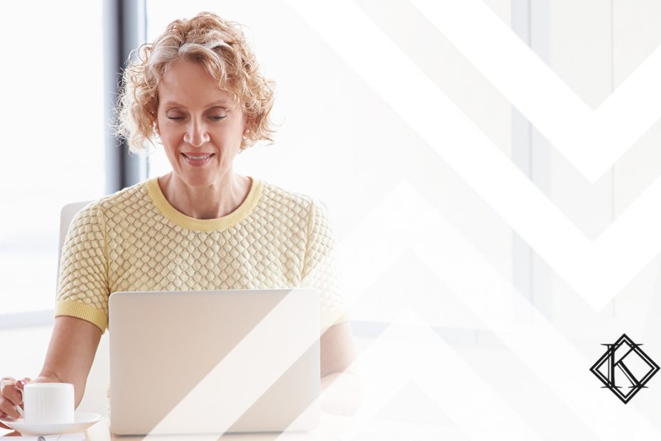 A imagem mostra uma mulher à mesa, usando o computador, e ilustra a publicação "Receber aposentadoria e continuar trabalhando, é possível?", da Koetz Advocacia.