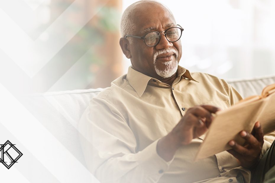 A imagem mostra um homem no sofá, lendo, e ilustra a publicação "Revisão de aposentadoria no INSS: opções e como fazer o pedido", da Koetz Advocacia.