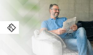 A imagem mostra um homem sentado no sofá, sorrindo, e ilustra a publicação 