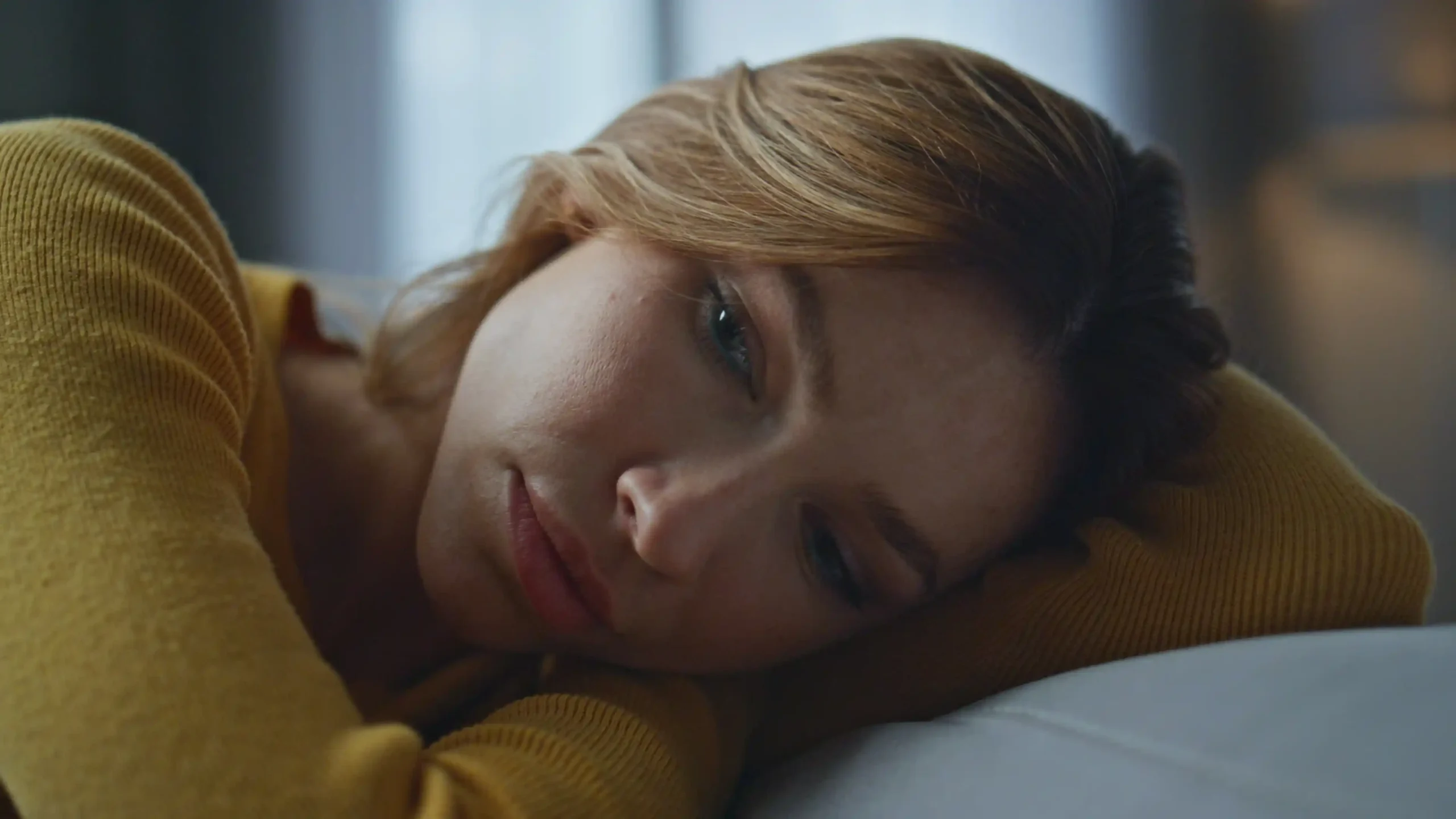 A imagem mostra uma jovem mulher deitada na cama, com expressão séria. Ilustra o texto sobre incapacidade temporária.