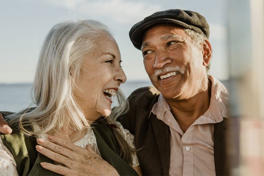 A imagem mostra um casal maduro, sorrindo um para o outro. A imagem ilustra o texto 