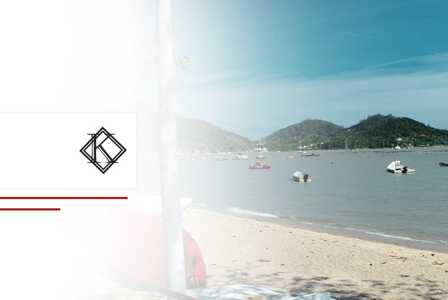 A imagem mostra uma praia de Florianópolis, no Brasil, com areia e água cristalina, além de embarcações ao fundo e ilustra o texto: Florianópolis: a joia imobiliária do sul do Brasil da Koetz Advocacia.