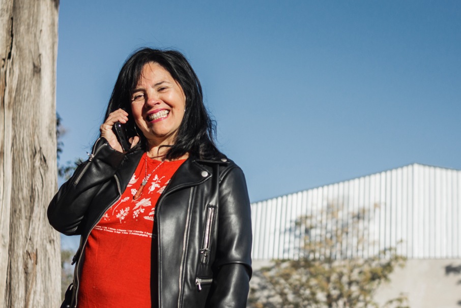 La imagen muestra a una mujer madura sonriente haciendo llamadas telefónicas. ilustrando el articulo 