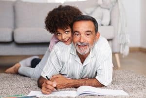 A imagem mostra o neto e seu vó, desenhando juntos. A imagem ilustra o texto 