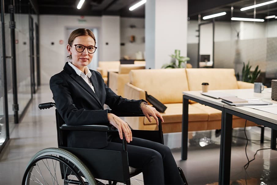 A imagem mostra uma mulher de negócios em uma cadeira de rodas. A imagem ilustra o texto 