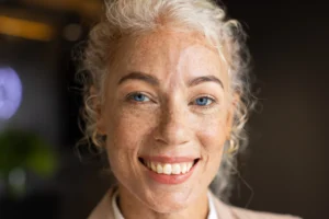 A imagem mostra uma mulher de meia-idade, sorrindo para a câmera. Ilustra o texto da aposentadoria para mulher.