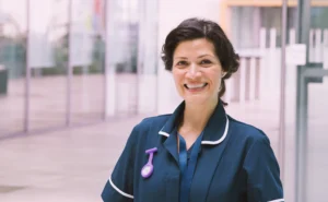 A imagem mostra uma enfermeira madura, olhando para a câmera e sorrindo. Ilustra o texto sobre Aposentadoria especial do Enfermeiro.