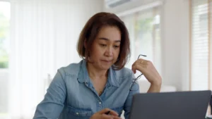 A imagem mostra uma mulher de meia-idade usando o laptop. Ilustra o texto sobre mandado de segurança contra o INSS,