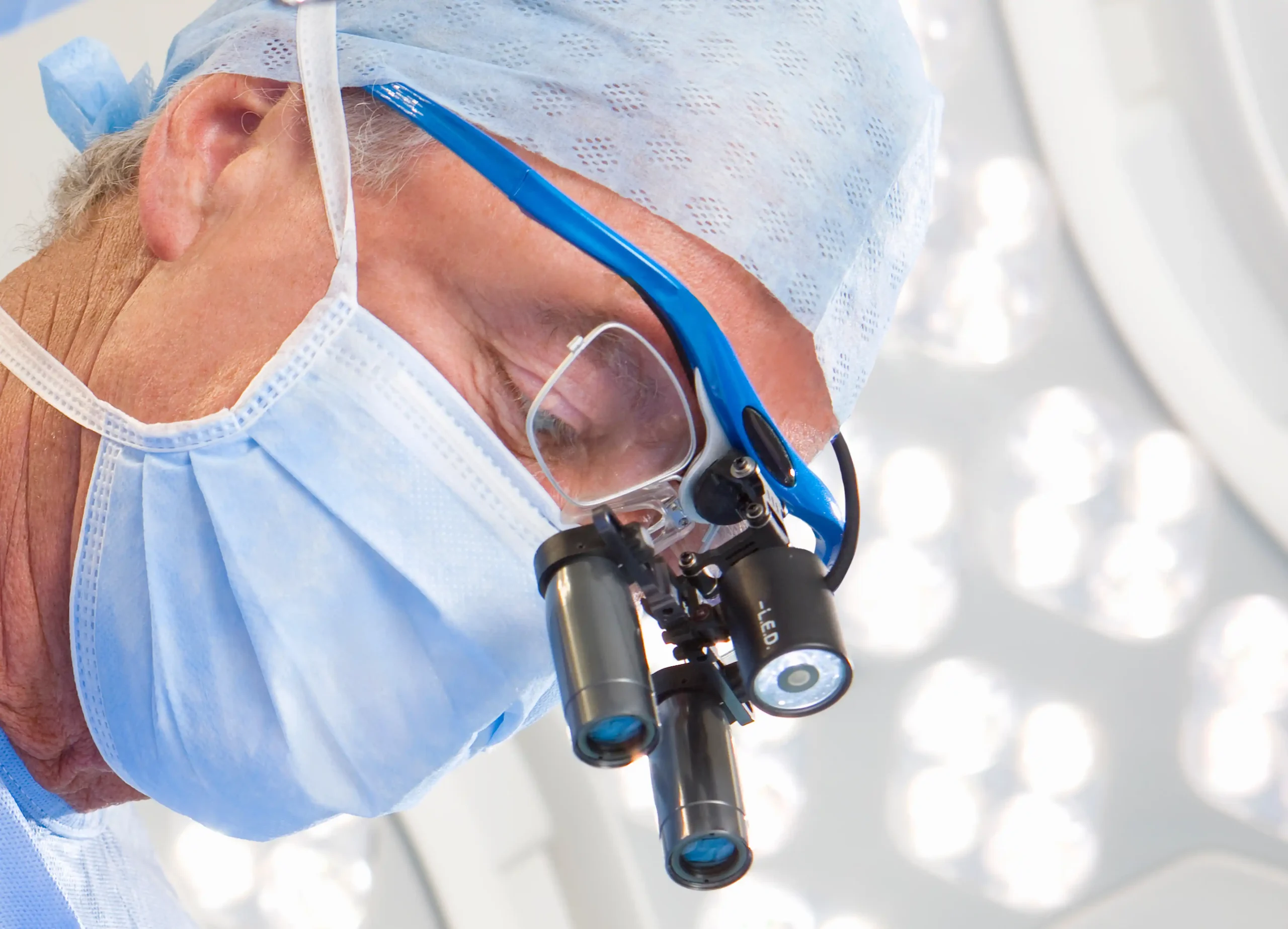 A imagem mostra um médico, vestido com roupas cirúrgicas no centro cirúrgico. Ilustra o texto sobre médico aposentado continuar trabalhando.