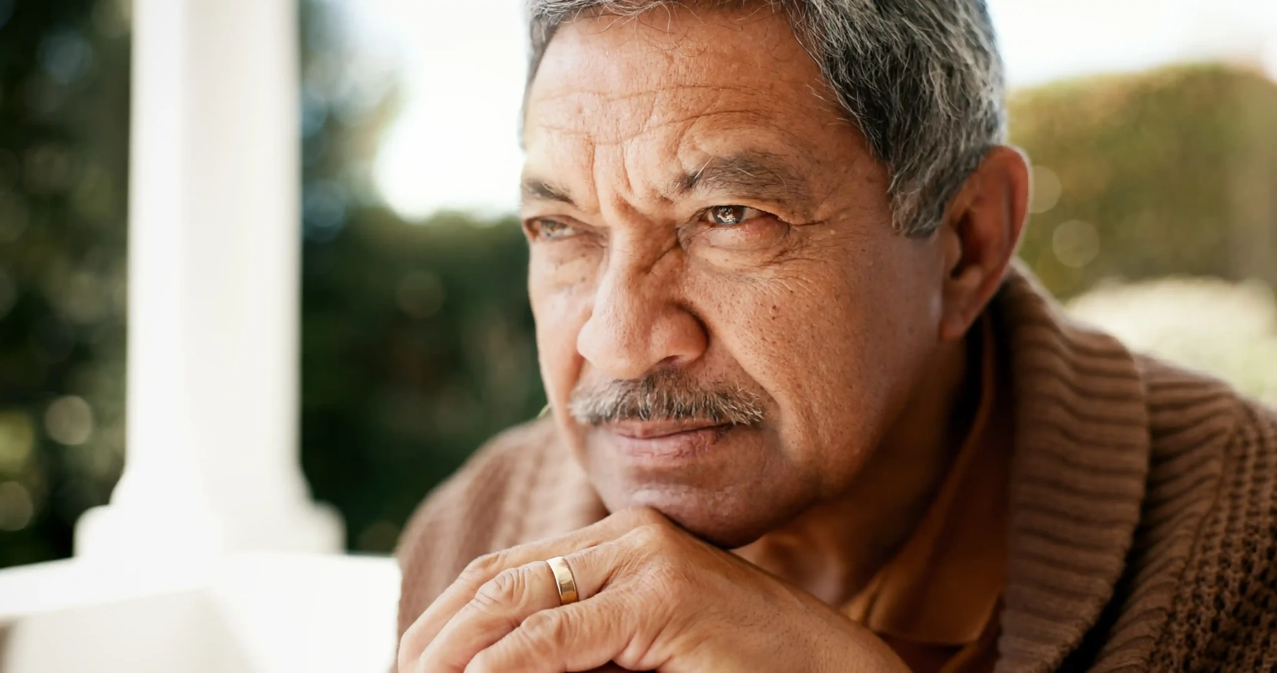 A imagem mostra um homem de meia-idade, com expressão seria, olhando para o horizonte. Ilustra o texto sobre isenção de imposto de renda por doença grave.